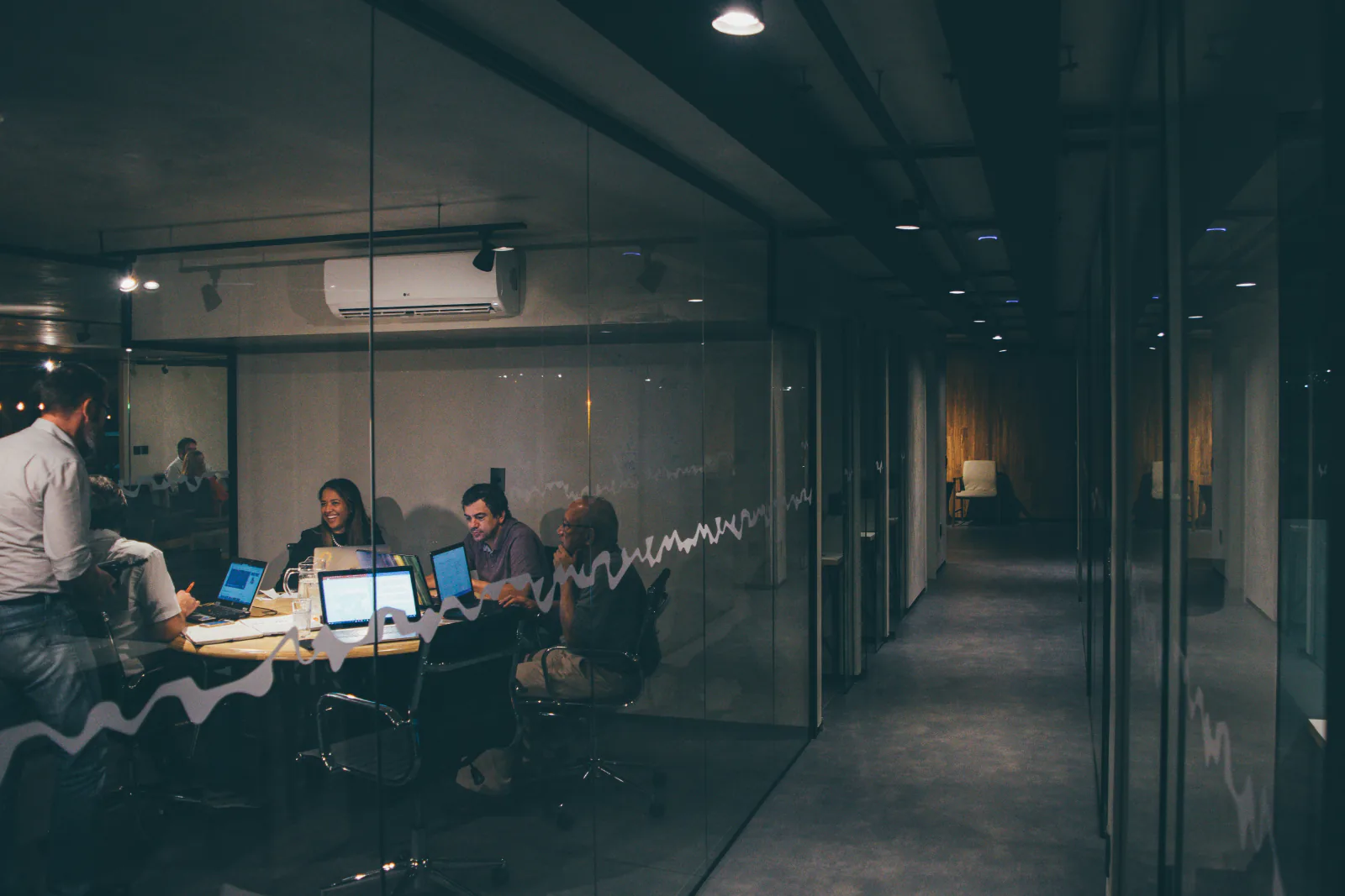 A meeting in a glass walled office in the evening