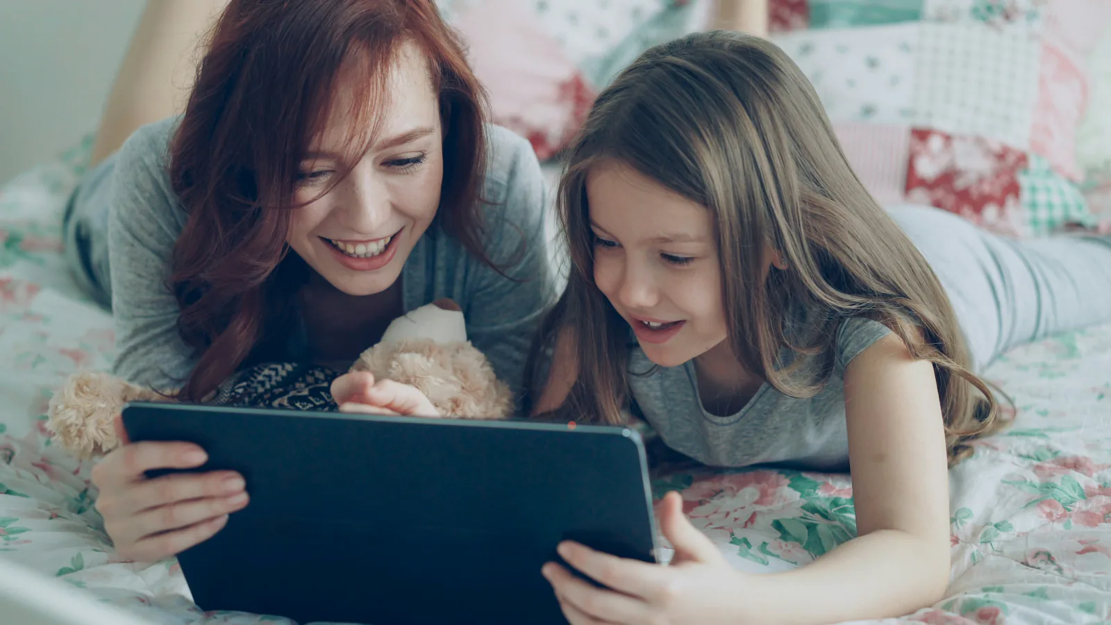 A parent and child watching a tablet at home