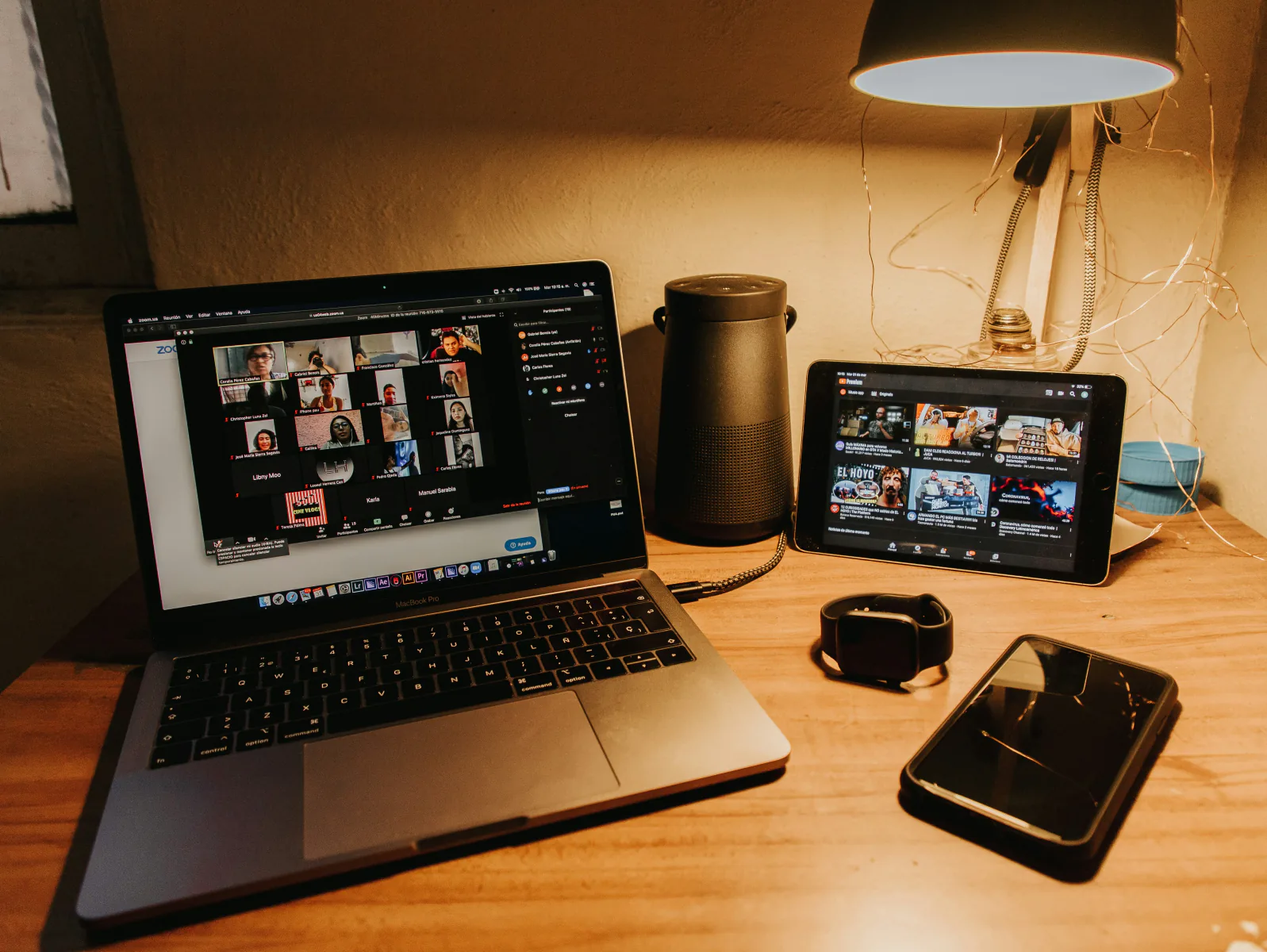 A laptop and tablet streaming on a desk at night