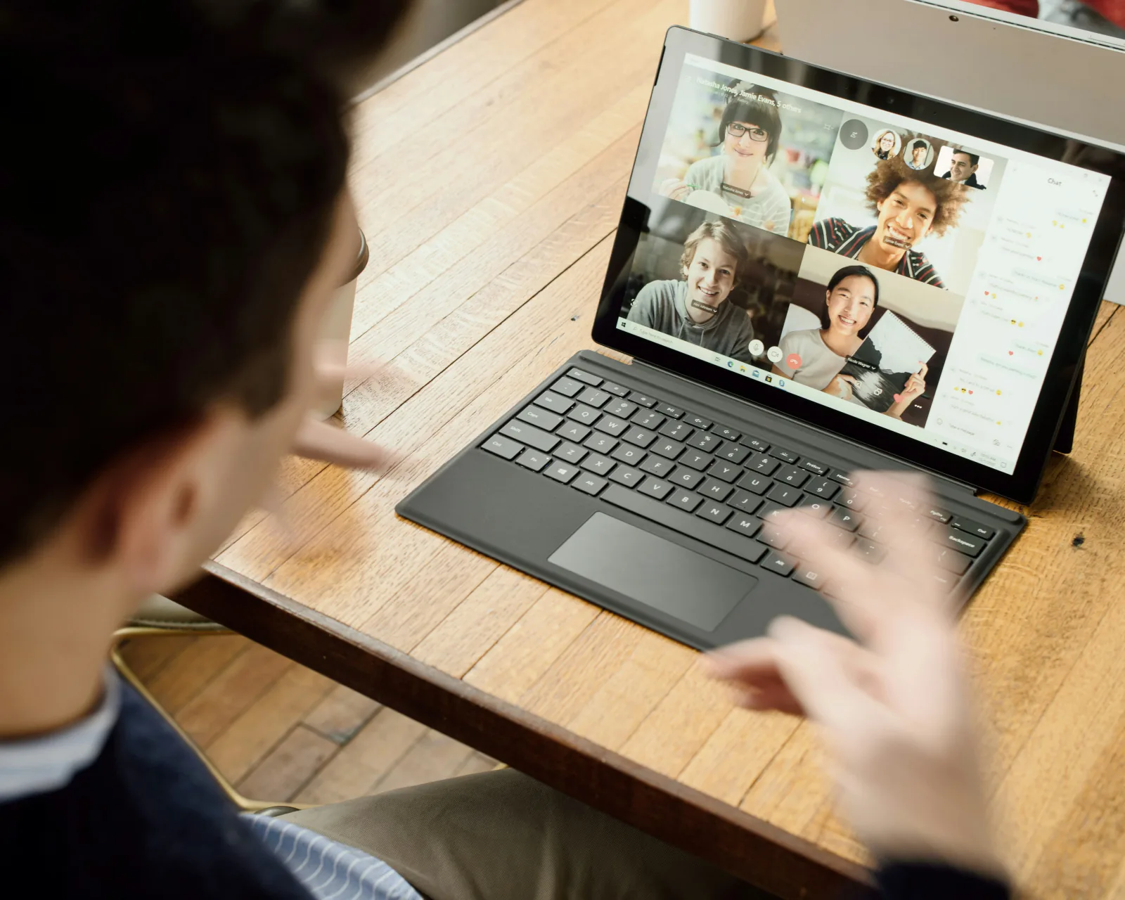 A person on a video call at a kitchen table
